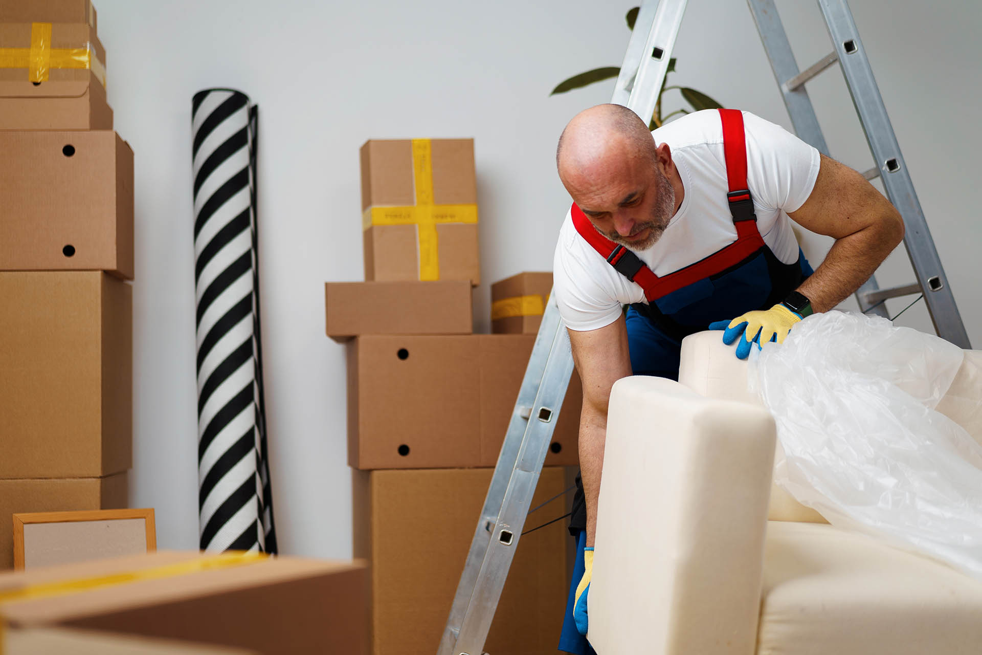 Man mover in uniiform packing sofa for relocation, close up