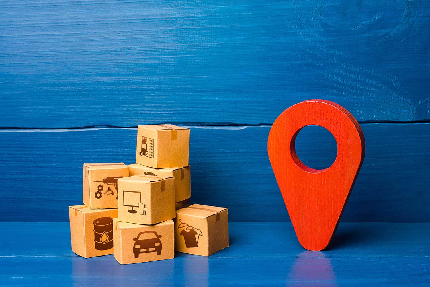 red-location-pointer-symbol-and-cardboard-boxes-min